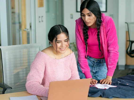 two college girls looking at a laptop
