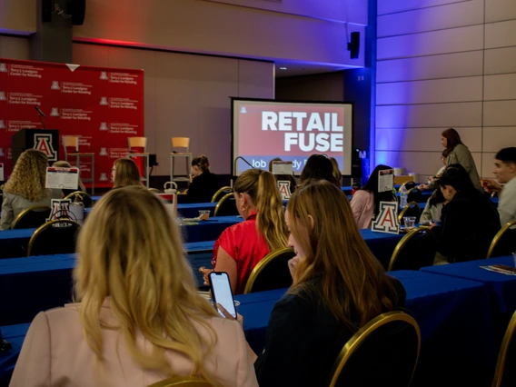 A group of students sitting at tables during the 2024 Retail Fuse event.