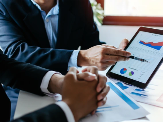 Picture of man showing another man graphs on a screen