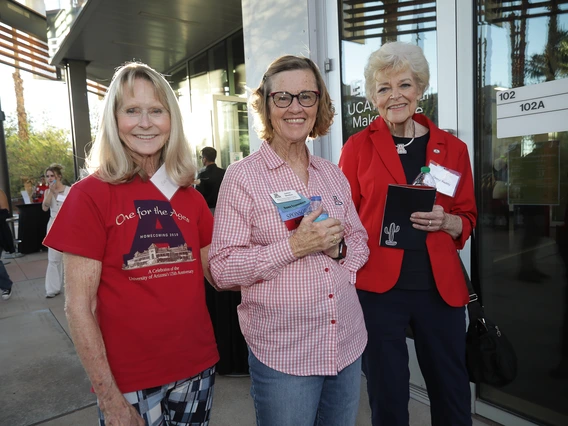 Three Norton alumni pose for a photo in their Wildcat colors