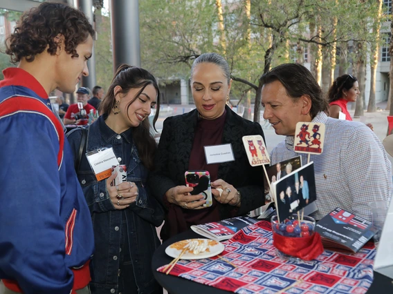 Norton students and alumni gather around a table at the 2025 Homecoming auction