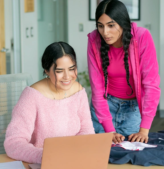 two college girls looking at a laptop