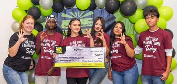 students holding a large check