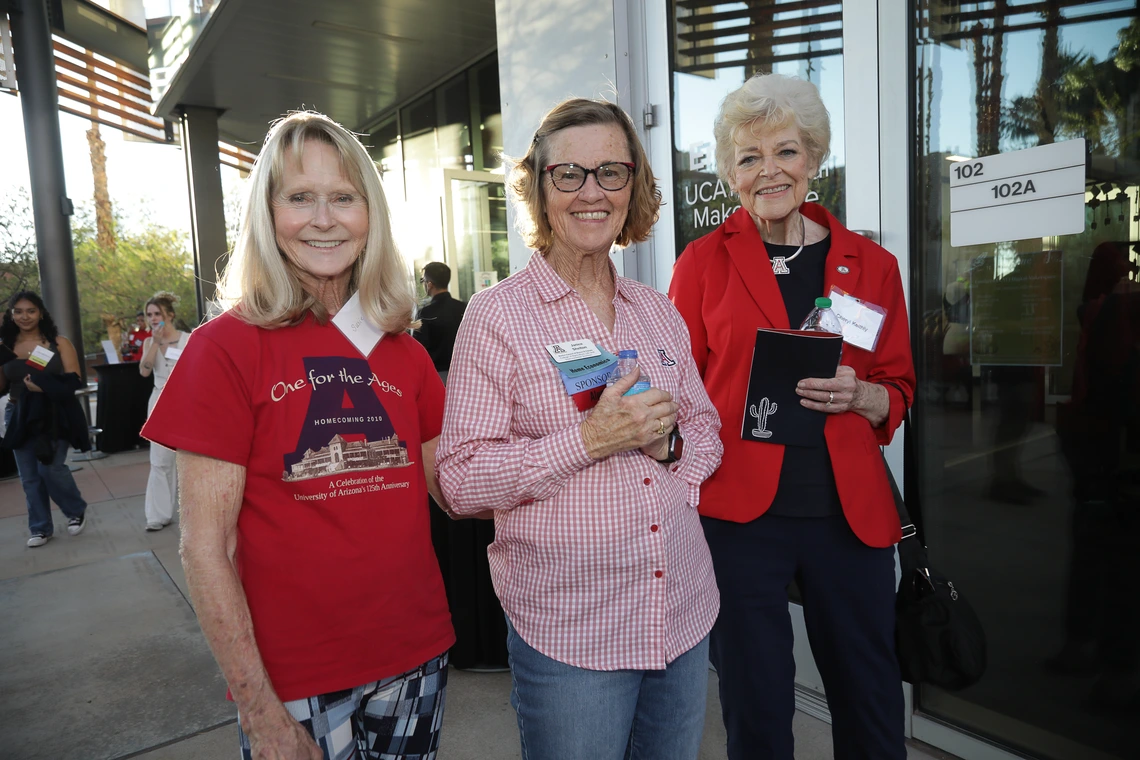 Three Norton alumni pose for a photo in their Wildcat colors