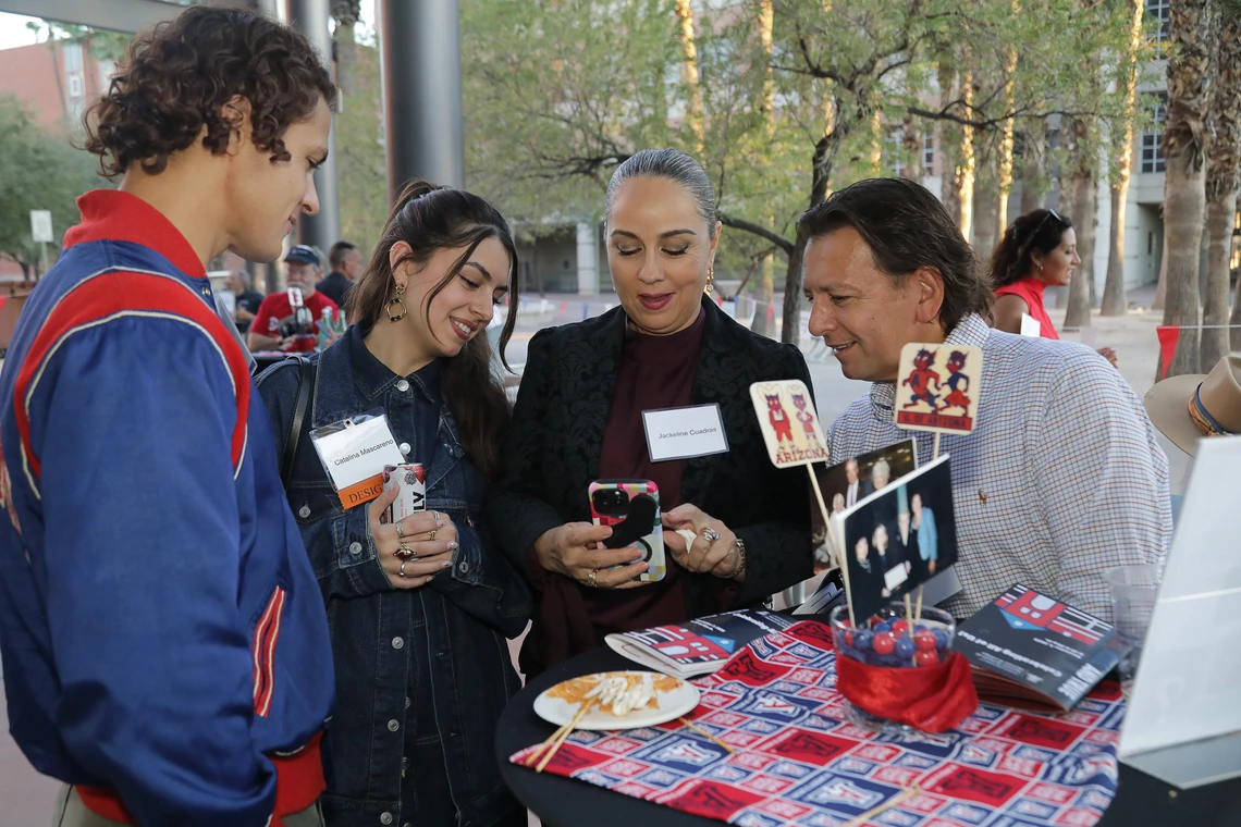Norton students and alumni gather around a table at the 2025 Homecoming auction