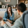 A heterosexual couple sits on a couch across from their therapist