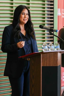 A person stands at a podium addressing a crowd.