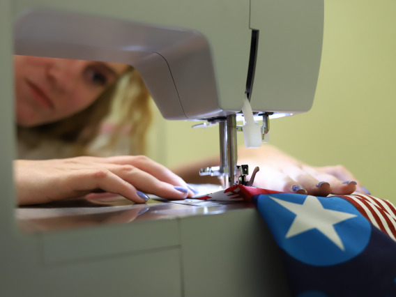 A girl sewing on an electric machine.